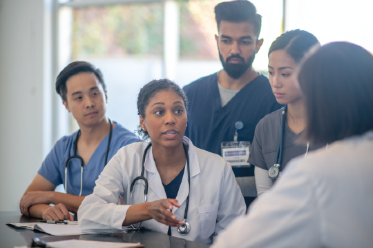 Healthcare workers collaborating around a desk.