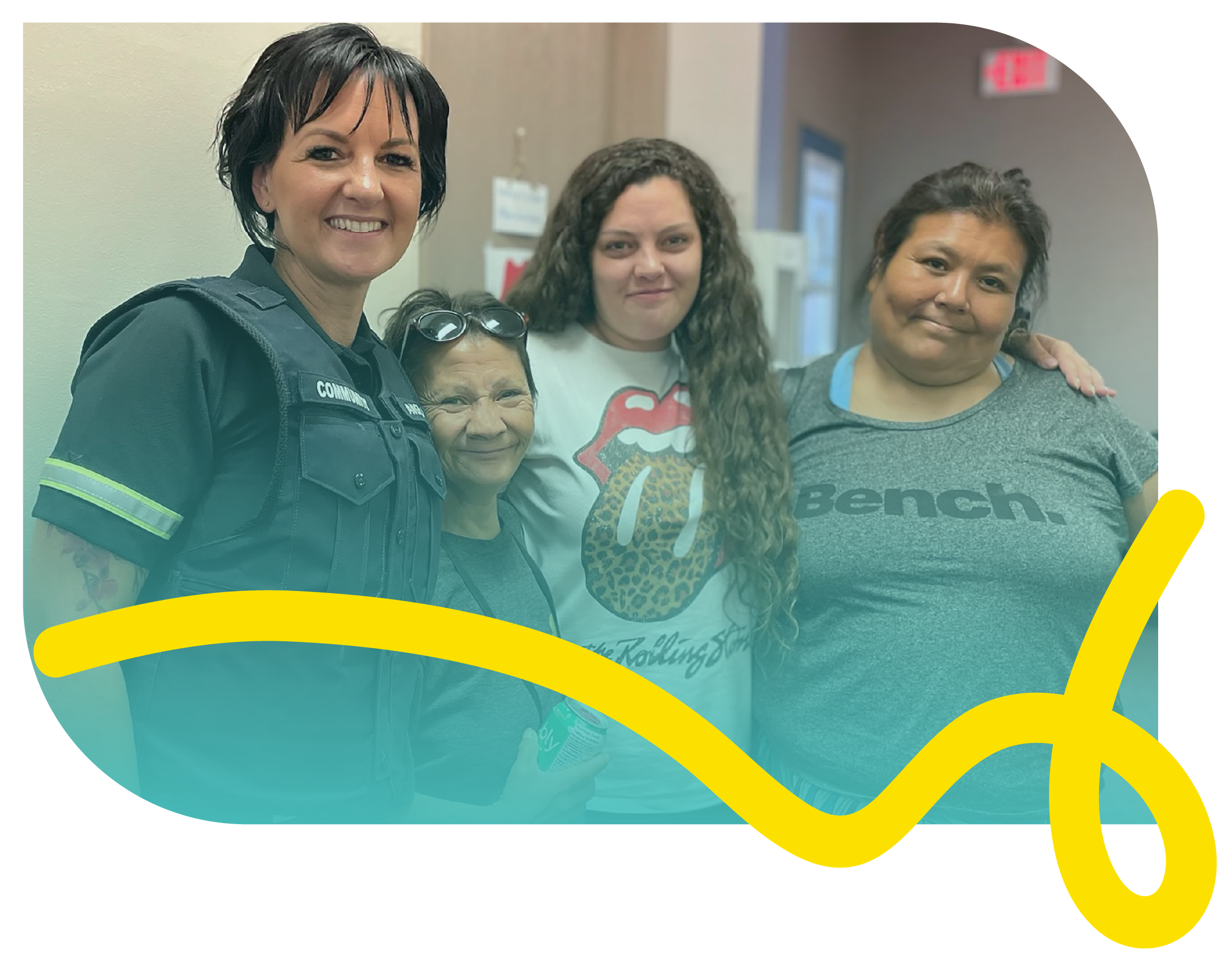 A uniformed paramedic stands with three  individuals from the community.
