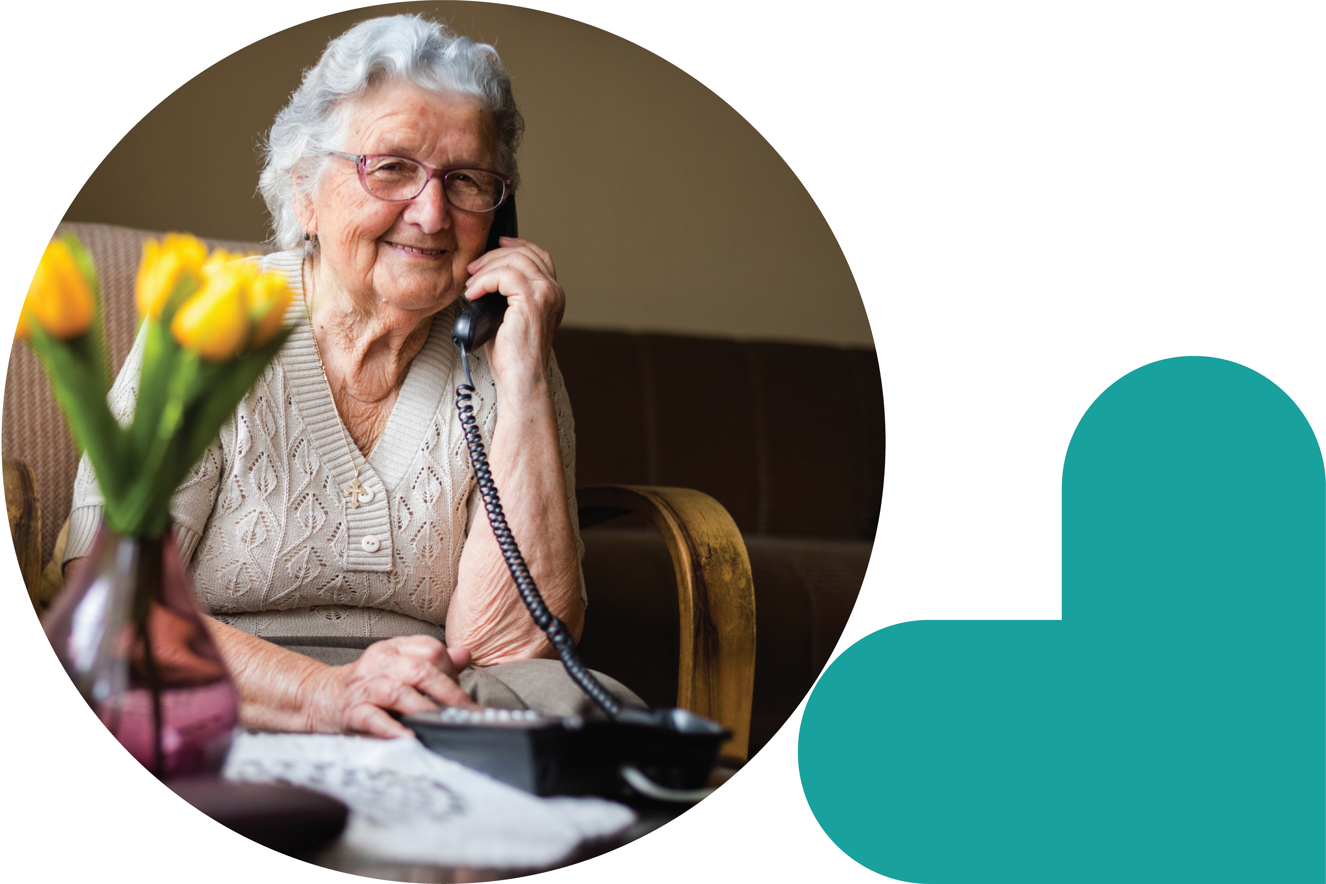 An older adult sitting in an armchair and talking on the phone.