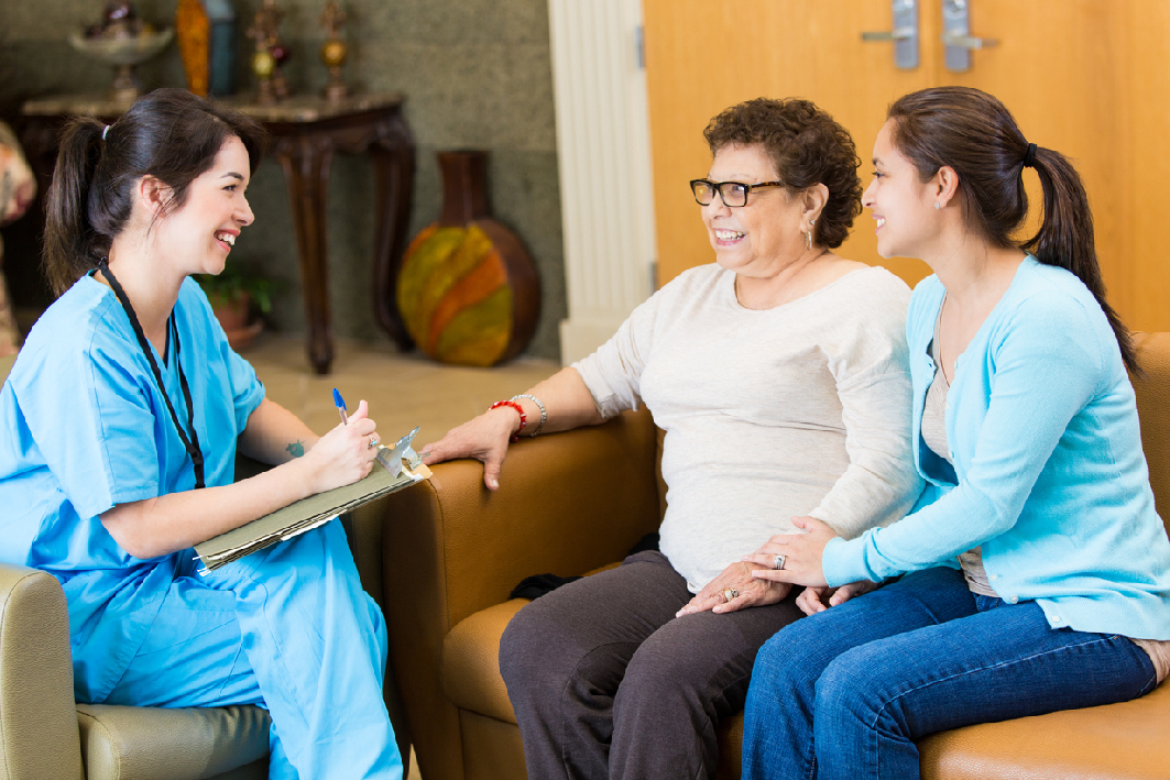 Smiling healthcare worker speaking to a family