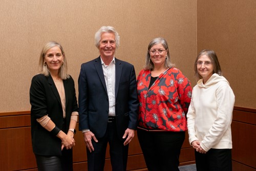 Four CIUSSSMCQ team members standing together and smiling in a meeting room.